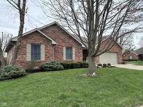 Brick home featuring mature trees, shutters, and an attached garage at 1066 Woodridge, Brownsburg, IN 46112