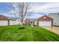 Charming home featuring a brick facade, well-manicured lawn, and attached two-car garage at 12319 Wolf Run Rd, Noblesville, IN 46060