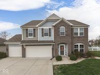 Charming two-story home featuring a brick facade, three-car garage, manicured lawn, and tasteful landscaping at 1232 Blue Haven Way, Greenwood, IN 46143