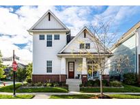 Charming two-story home with a brick foundation, eye-catching red front door, and beautiful landscaping at 1401 Farmhouse Dr, Westfield, IN 46074