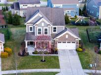 Well maintained two-story home with a brick and vinyl exterior, two car garage, and landscaped front yard at 14059 Knightstown E Dr, Carmel, IN 46033
