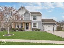 Charming two-story home featuring a well-manicured lawn, covered porch, and attached two car garage at 1458 Longleaf St, Avon, IN 46123