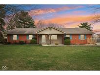 Charming single-story brick home features colorful shutters, landscaped yard, and inviting entrance at 1526 Chapman Dr, Greenfield, IN 46140