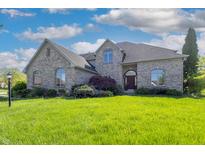 Charming brick home featuring manicured lawn, elegant landscaping, and traditional architectural design at 3256 Waterside Ct, Greenwood, IN 46143