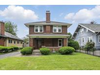Charming brick two-story home featuring a landscaped front yard and classic architectural details at 4720 Central Ave, Indianapolis, IN 46205
