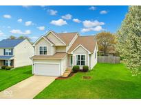 Charming two-story home with manicured lawn and attached garage, featuring beautiful curb appeal and landscaping at 6064 Brandermill Rdg, Columbus, IN 47203