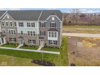Attractive townhome with stone accents, blue shutters, and professionally landscaped front yard at 6265 Loraine Dr, Brownsburg, IN 46112
