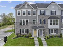 Two-story townhome featuring stone accents, gray siding, professionally landscaped front yard, and inviting entrances at 6309 Loraine Dr, Brownsburg, IN 46112
