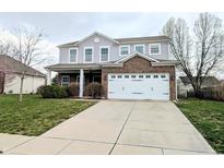 Charming two-story home featuring a brick facade, attached garage, and well-manicured front lawn at 8404 Alcona Dr, Indianapolis, IN 46237