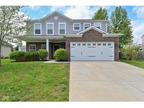 Charming two-story home with a brick and gray siding facade, a two-car garage, and manicured landscaping at 8404 Alcona Dr, Indianapolis, IN 46237