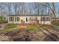 Inviting single-story home with a charming front porch and well-maintained landscaping at 10614 W Hickory Ct, Quincy, IN 47456