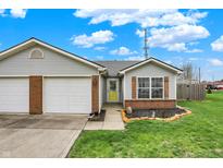 Charming single-story home with a two-car garage, brick accents, and a well-manicured lawn at 1077 Wild Ivy Trl, Franklin, IN 46131