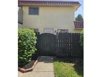 Charming townhome featuring tan siding, a brown tile roof and enclosed by a decorative black fence at 2804 Paso Del Norte Dr, Indianapolis, IN 46227