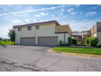 Two-story exterior view of townhomes with attached garages and well maintained landscaping at 2804 Paso Del Norte Dr, Indianapolis, IN 46227