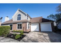 Charming two-story home featuring a two-car garage, landscaped yard, and brick and siding accents under a clear, blue sky at 3260 Eddy Ct, Indianapolis, IN 46214