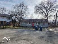 Charming single-story home with a well-maintained lawn and a bright red front door at 3844 Esquire Ct, Indianapolis, IN 46226