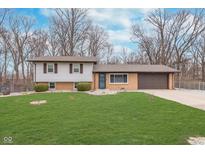 Charming two-story home with green lawn, brick facade, attached garage and mature trees at 516 Hanover Dr, Anderson, IN 46012