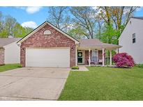 Charming brick home featuring a two-car garage, a cozy front porch, and a well-maintained lawn at 5541 Fair Ridge Pl, Indianapolis, IN 46221