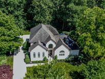Aerial view of a two-story home featuring a large, well-manicured yard, a multi-car driveway, and mature trees at 7957 Preservation Dr, Indianapolis, IN 46278