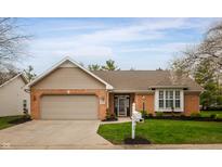 Charming brick home featuring an attached garage, well-manicured lawn, and blossoming trees at 2813 W Long Meadow Ln, Muncie, IN 47304