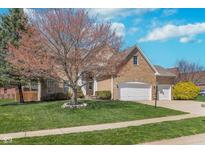 Charming brick home with a well-manicured lawn and mature tree at 4421 Brittany Dr, Zionsville, IN 46077