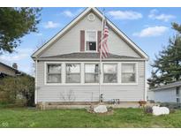 Charming gray home featuring a quaint front yard with a delightful American flag at 443 S Arlington Ave, Indianapolis, IN 46219