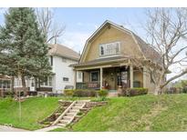 Charming two-story home with a front porch and landscaped front yard. Steps lead to the front door at 616 N Bancroft St, Indianapolis, IN 46201