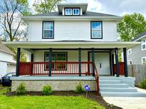 Beautiful two-story home with a charming front porch, green lawn, and fresh landscaping at 625 N Parker Ave, Indianapolis, IN 46201