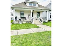 Charming home with a covered front porch, decorative railings, and well-maintained lawn at 640 W South St, Shelbyville, IN 46176