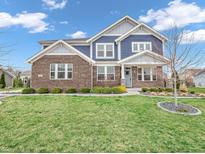 Charming two-story home with a brick facade, blue siding, manicured lawn, and inviting curb appeal at 682 Keswick Dr, Brownsburg, IN 46112