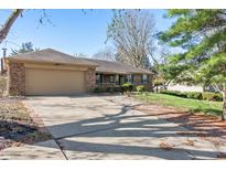 Charming brick ranch with attached two-car garage and well-manicured lawn and professional landscaping at 745 W Banta Rd, Indianapolis, IN 46217