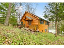 Charming log cabin home with a cozy front porch and a view of the lake at 7591 Inkbush Dr, Nineveh, IN 46164