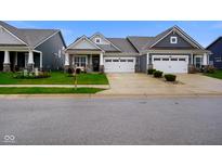 Charming gray home featuring a two-car garage, well-manicured lawn and cozy front porch at 8160 Nik St, Brownsburg, IN 46112