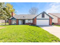Charming single-story home featuring a well-manicured lawn, two-car garage, and brick accents at 923 Jonathan Dr, Plainfield, IN 46168