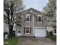 Charming two-story home with neutral siding, garage, and flowering trees in a well-maintained yard at 1254 Kenwood Dr, Greenwood, IN 46143