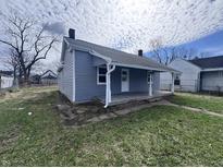 Charming home with light blue siding, a cozy front porch, and a well-maintained lawn at 1445 S Belmont Ave, Indianapolis, IN 46221