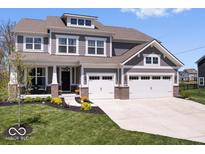 Beautiful two-story home boasts a manicured lawn, a two-car garage and a charming front porch with brick accents at 16688 Bowesmont Dr, Fortville, IN 46040