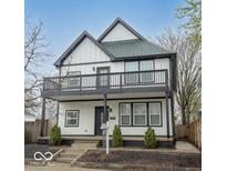 Two-story home with black and white trim, a second-story deck, and manicured landscaping at 221 Eastern Ave, Indianapolis, IN 46201