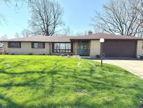 Charming single-story brick home with attached garage and large front yard at 243 E Benton St, Alexandria, IN 46001