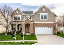 Charming two-story home featuring a manicured lawn, brick accents, and an attached two-car garage at 3393 Paisley Pointe, Whitestown, IN 46075