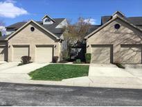Charming townhouse exterior showcasing attached garages, well-maintained lawns and a classic brick facade at 3643 Reflections Ln # 5, Indianapolis, IN 46214