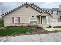 Charming townhouse featuring vinyl siding, red shutters, and brick foundation at 4767 Kelvington Dr, Indianapolis, IN 46254