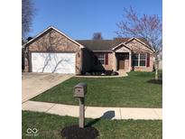 Charming single-story brick home featuring a well-manicured lawn and attached two-car garage at 5528 Wheatstone Ct, Indianapolis, IN 46221