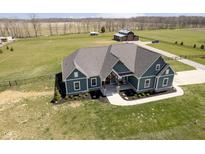 Stunning aerial view of a modern home with a well-manicured lawn and large barn on expansive acreage at 5679 S 675 W, New Palestine, IN 46163