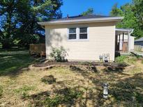Backyard view of house showing yard, garden beds, and deck at 5820 Bonnie Brae St, Indianapolis, IN 46228
