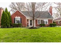 Charming brick home featuring manicured lawn, classic architectural details and a welcoming front entrance at 6041 Garver Rd, Indianapolis, IN 46208