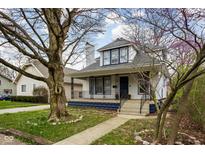 Charming two-story home with a covered front porch, mature trees, and beautiful curb appeal at 6208 Broadway St, Indianapolis, IN 46220