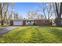 Charming single-story brick home featuring an attached garage and well-maintained front lawn at 8017 Wallingwood Dr, Indianapolis, IN 46256