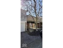 Home exterior with a brick and gray siding, featuring a balcony and mature trees in the landscape at 8277 Sobax Dr, Indianapolis, IN 46268