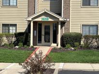 Inviting condo front entrance with well manicured landscaping and walkway, number 8820 above door at 8820 Yardley Ct # 103, Indianapolis, IN 46268
